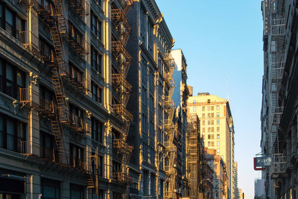 Warm light of sunset shining down a block of buildings in New York City NYC
