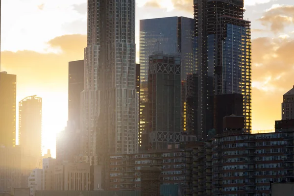 La luz del atardecer brilla a través del horizonte de la ciudad de Nueva York de estilo moderno — Foto de Stock