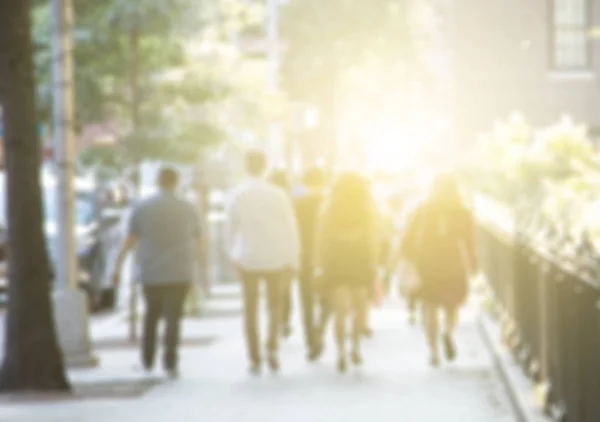 Group of young people walking down the sidewalk into the glowing