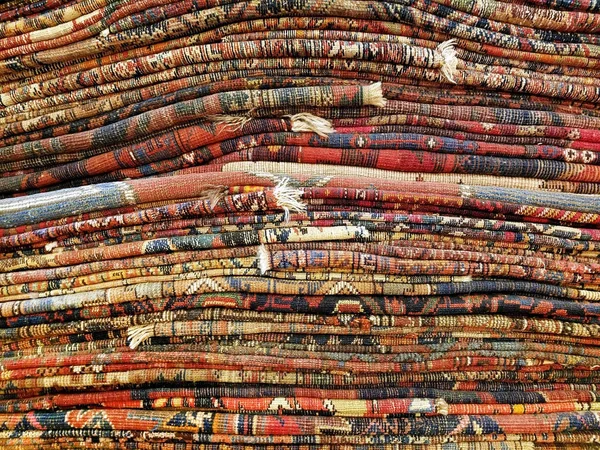 Stack of colorful handmade Oriental style rugs background