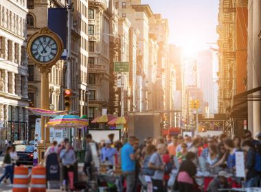 Güneş ışığı parlıyor kişiler ve Manhattan'ın binalar