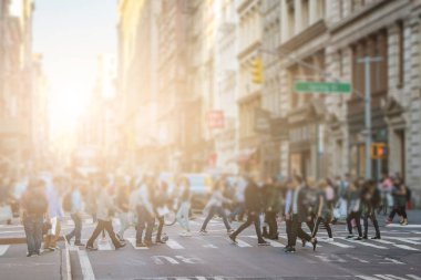 Anonymous crowd of people walking across the intersection in SoHo New York City clipart