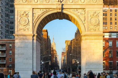 New York'ta Midtown silueti manzarası ile gün batımında Washington Square Park'ta Insanlar