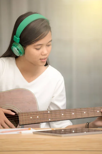 Genç kız gitar çalmak ve müzik bestelemek — Stok fotoğraf