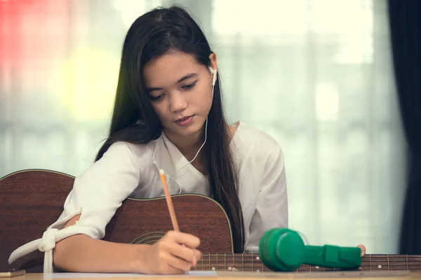 Genç kız gitar çalmak ve müzik bestelemek — Stok fotoğraf