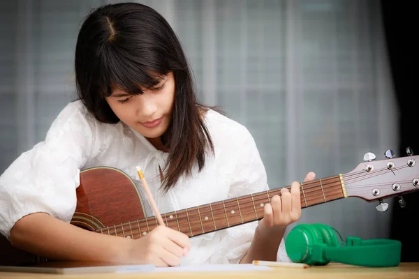 Genç kız gitar çalmak ve müzik bestelemek — Stok fotoğraf