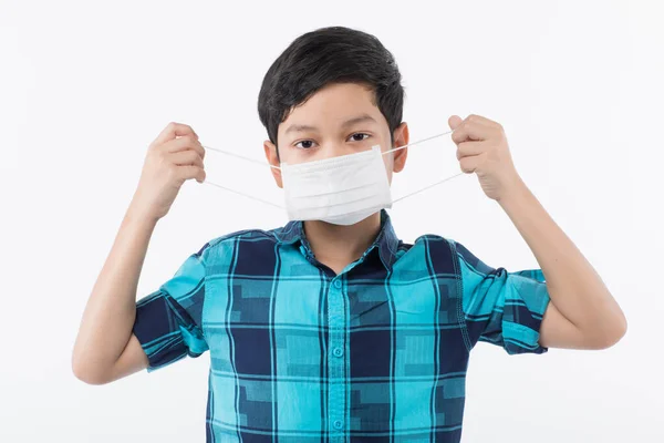 若いアサインの少年は外科用保護マスクを保持し 顔にそれを着用する方法を示す準備ができています コロナウイルスの発生や大気汚染のリスクから子供を防ぐためのアイデア — ストック写真