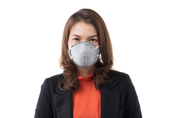 Beautiful Asian woman in casual business dress wearing surgical hygiene protect mask on white background and looking at camera. Idea for prevention from coronavirus outbreak and safe in pollution air.