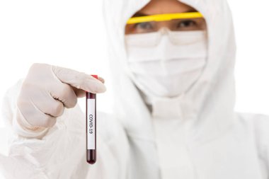 Steriliz laboratuvar önlüğü giyen bilim adamı elinde Covid-19 test tüpü örneği tutuyor. Virüsün adı üzerine seçici odaklanma. Coronavirüs 'ü yenmek için araştırma yapan tıp insanları için konsept.