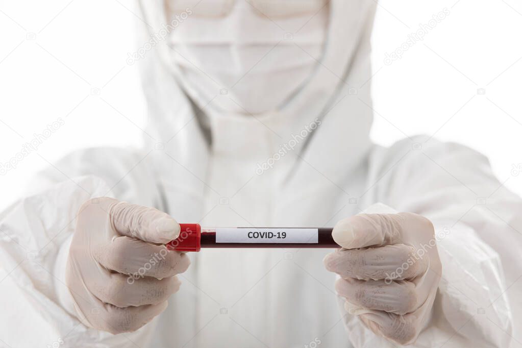 Scientist in sterilizes lab coat cloth holding Covid-19 test tube sample in hand. Selective focus on the name of virus. Concept for medical people trying and researching for win over coronavirus.