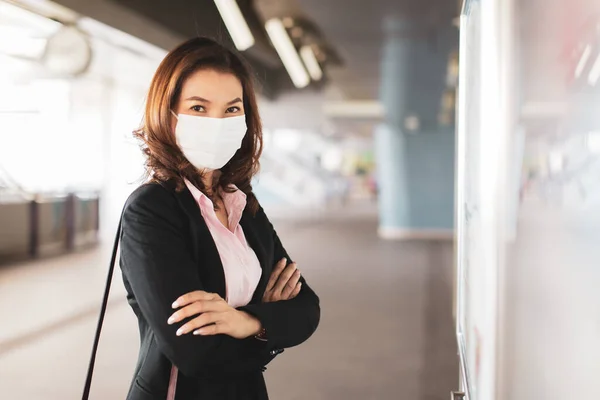 Die Schöne Asiatin Schwarzen Anzug Mit Medizinischer Hygiene Schutzmaske Steht lizenzfreie Stockfotos