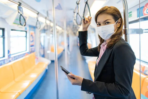 Asijská Podnikatelka Pasažérka Která Nosí Masku Zdravotní Hygieny Používá Smartphone — Stock fotografie