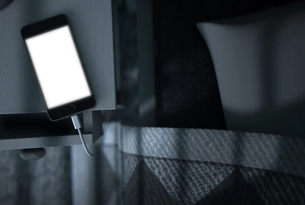 Leuchtetes Handy neben dem Bett — Stockfoto