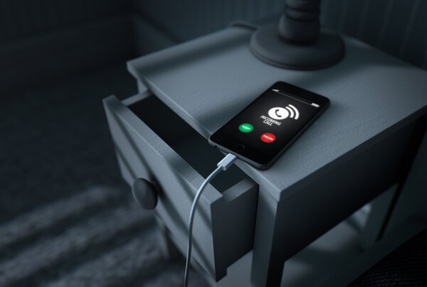 Входящий звонок на мобильный телефон рядом с кроватью
