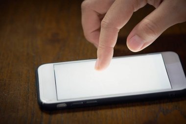 Bir kadının işaretçi dokunur veya tahtadan yapılmış bir masanın üzerine yerleştirilir mobil phone(smartphone) ekran dokunur. iş kavramı. kopya alanı.