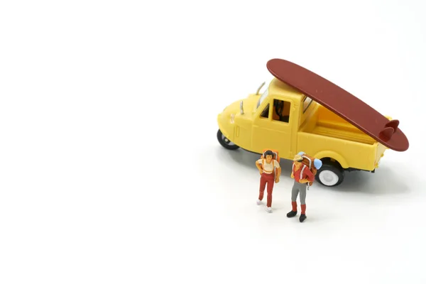 Miniatura 2 pessoas estão com modelo de carro de brinquedo como conceito de viagem de fundo com espaço de cópia . — Fotografia de Stock