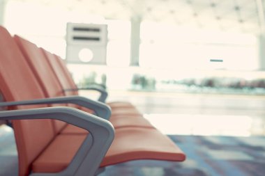 Yolcu kırmızı havaalanında bekleyen sandalyeler. Arka plan havalimanına atmosferde olduğunu. Bırakmak için bekleyen yolcular için veya havaalanında yalan olabilir. kopya alanı ile.