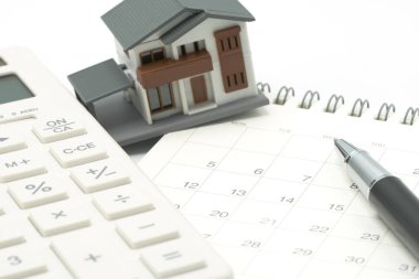 Bir modeli ev modeli bir takvim ve kalem üzerinde yer alıyor. arka plan özelliği gayrimenkul konsept olarak metin veya tasarım için kopya alanı ile.