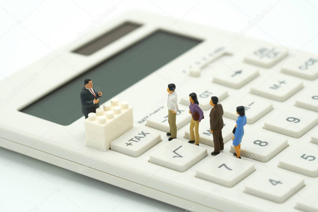Miniature people Pay queue Annual income (TAX) for the year on calculator. using as background business concept and finance concept with copy space  for your text or  design.