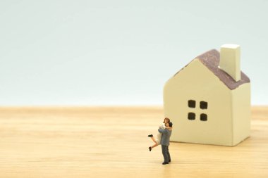 Model ev modeli ile duran çift minyatür 2 insanlar aile hissediyorum happy.as arka plan Emlak ve aile kavramı kopya alanı ile yapmak.
