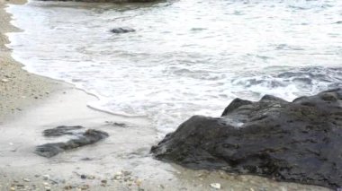 Yavaş dalgalar deniz plaj sahil kıyıları boyunca patlatmak. Deniz su erozyonu Relax ve rahat hissediyorum.