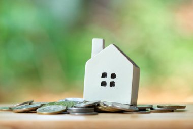 Bir modeli ev model arka plan iş kavramı ve kopya alanı metin veya tasarım için konseptiyle gayrimenkul olarak coins.using bir yığın yerleştirilir.