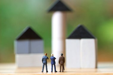 Yatırım Analizi Konutları veya Taşınabilir Gayrimenkullere Yatırım yapan Minyatür İşadamları. metin veya dizaynınız için kopyalama alanı ile arka plan iş kavramı ve emlak kavramı olarak kullanmak.