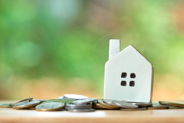 Bir modeli ev model arka plan iş kavramı ve kopya alanı metin veya tasarım için konseptiyle gayrimenkul olarak coins.using bir yığın yerleştirilir.