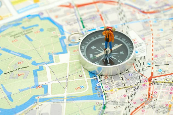 Miniature people standing travel planner on a compass with Japan map using as background  travel concept with copy spaces and white space for your.