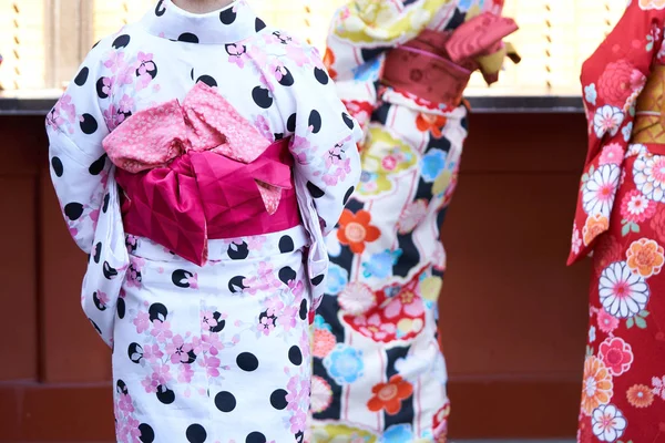 Young girl wearing Japanese kimono standing in front of Sensoji Temple in Tokyo, Japan. Kimono is a Japanese traditional garment. The word \