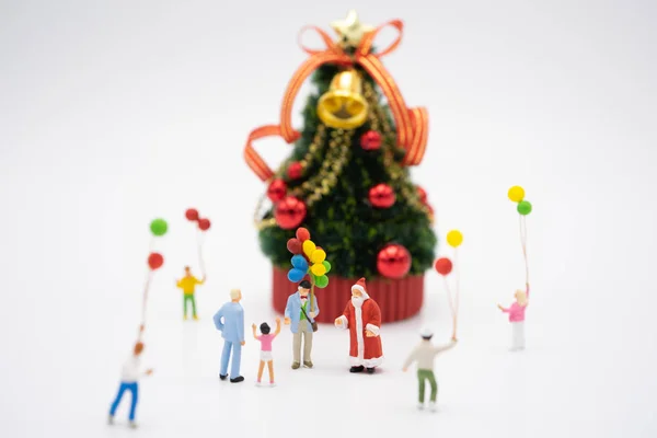 Семейные миниатюрные люди, стоящие на елке — стоковое фото