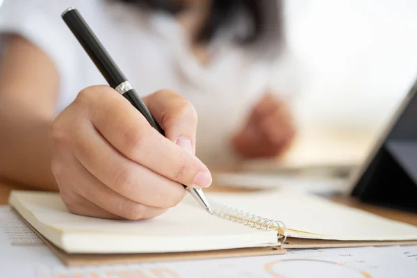 Close shot of businesswoman hands holding a pen writing somethin — Stock Photo, Image