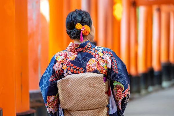 Geishas meisje draagt Japanse kimono tussen rode houten Tori Gate — Stockfoto
