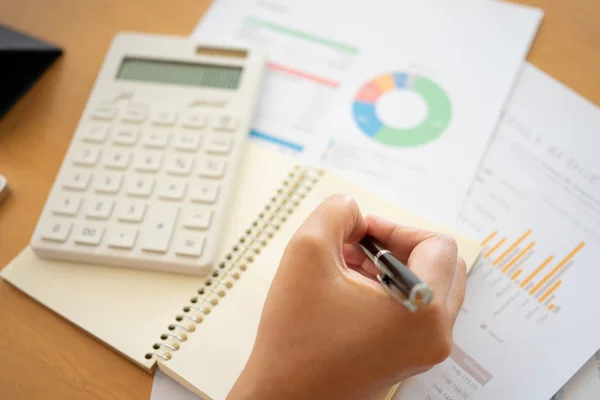 Primer plano de manos de empresaria sosteniendo un bolígrafo escribiendo algo — Foto de Stock