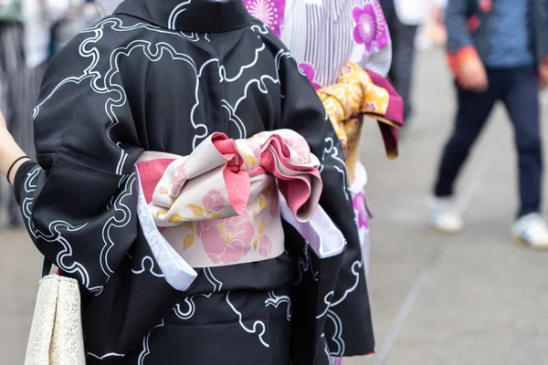 Ung flicka klädd i japansk kimono stående framför Sensoji — Stockfoto