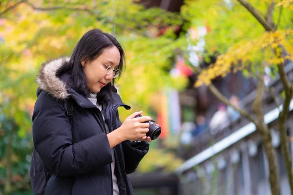 Junge schöne Fotografin mit der professionellen Kamera — Stockfoto