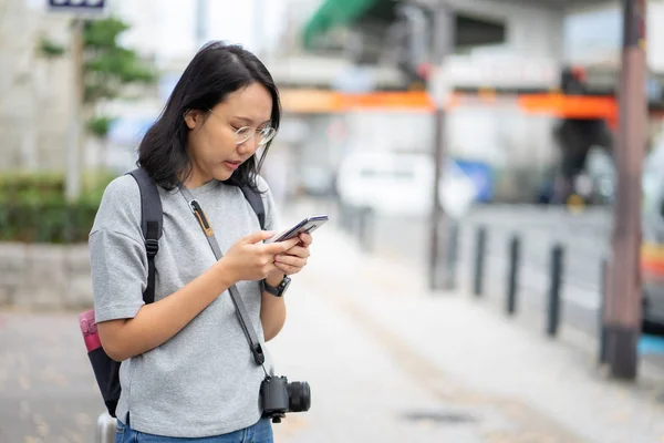 Hermosa mujer asiática viajero utiliza un teléfono inteligente en el centro de la ciudad —  Fotos de Stock