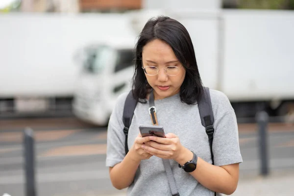 Hermosa mujer asiática viajero utiliza un teléfono inteligente en el centro de la ciudad —  Fotos de Stock