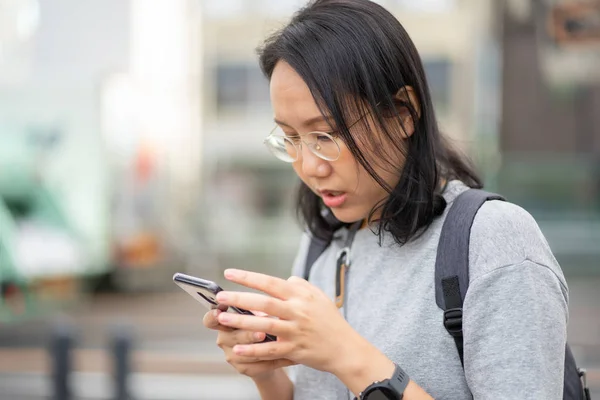 Hermosa mujer asiática viajero utiliza un teléfono inteligente en el centro de la ciudad —  Fotos de Stock