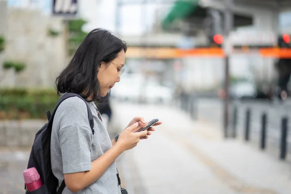 Hermosa mujer asiática viajero utiliza un teléfono inteligente en el centro de la ciudad —  Fotos de Stock