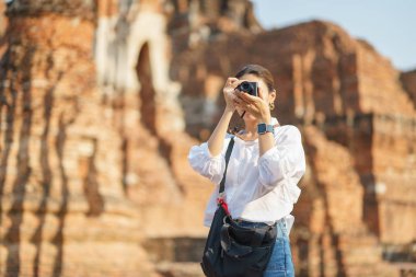 Güzel Asyalı turistler yürüyorlar, fotoğraf çekiyorlar ve seyahat ediyorlar.