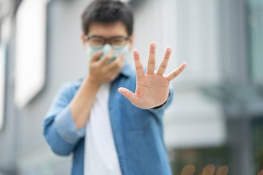 Yüz maskesi takan yakışıklı erkek hava kirliliğine karşı filtre (Pm2.5) ya da N95 maskesi takar. Çevre kirliliğini, hava kirliliğini ve virüsleri korumak sağlık sorunlarına yol açtı. Küresel ısınma kavramı.