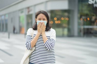Yüz maskesi takan kadın hava kirliliğine karşı filtre ya da N95 maskesi takıyor. Çevre kirliliğini, hava kirliliğini, hava kirliliğini ve Covid 19 virüsünü koruyun. Çevre kirliliği kavramı.