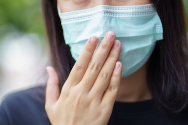 Yüz maskesi takan kadın hava kirliliğine karşı filtre ya da N95 maskesi takıyor. Çevre kirliliğini, hava kirliliğini, hava kirliliğini ve Covid 19 virüsünü koruyun. Çevre kirliliği kavramı.