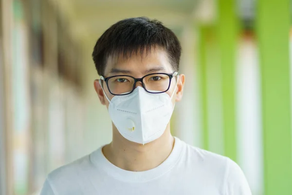 HandsomeMan wearing face mask protect filter against air pollution (PM2.5) or wear N95 mask. protect pollution, anti smog and Covid 19 viruses, Air pollution caused health problem. Global warming.