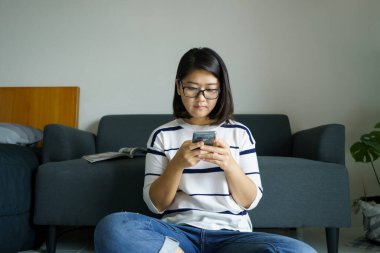 Akıllı telefonu olan, sosyal medyada gülümseyen, mesajlaşan, arkadaşlarıyla konuşan, müzik dinleyen, film izleyen güzel bir kadın. Sağlık konsepti ve mesafeyi koru