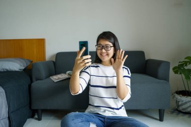 Akıllı telefonu olan, sosyal medyada gülümseyen, mesajlaşan, arkadaşlarıyla konuşan, müzik dinleyen, film izleyen güzel bir kadın. Sağlık konsepti ve mesafeyi koru