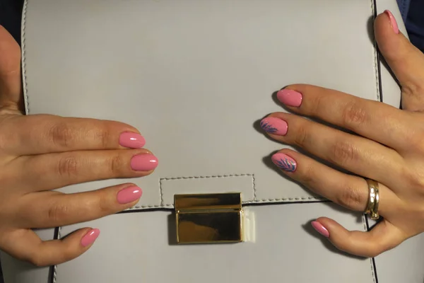 Maniküre rosa gefärbte Nägel auf weißem Leder Tasche Hintergrund — Stockfoto