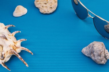 Seyahat düz düzen, kabukları ve taşlar mavi güneş gözlüğü