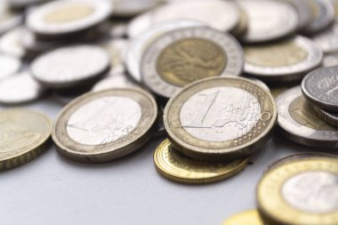 Işıkta bulanık arkaplanda birkaç avro bozuk para var. Yakın plan fotoğraf.